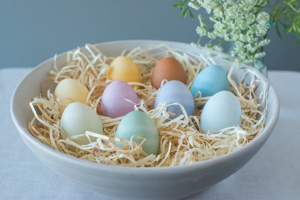 Vibrantly dyed eggs in ceramic bowl