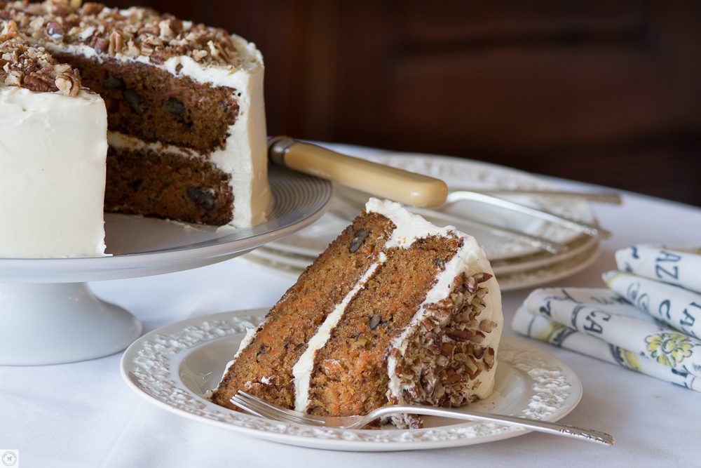Iced carrot cake with nuts on table