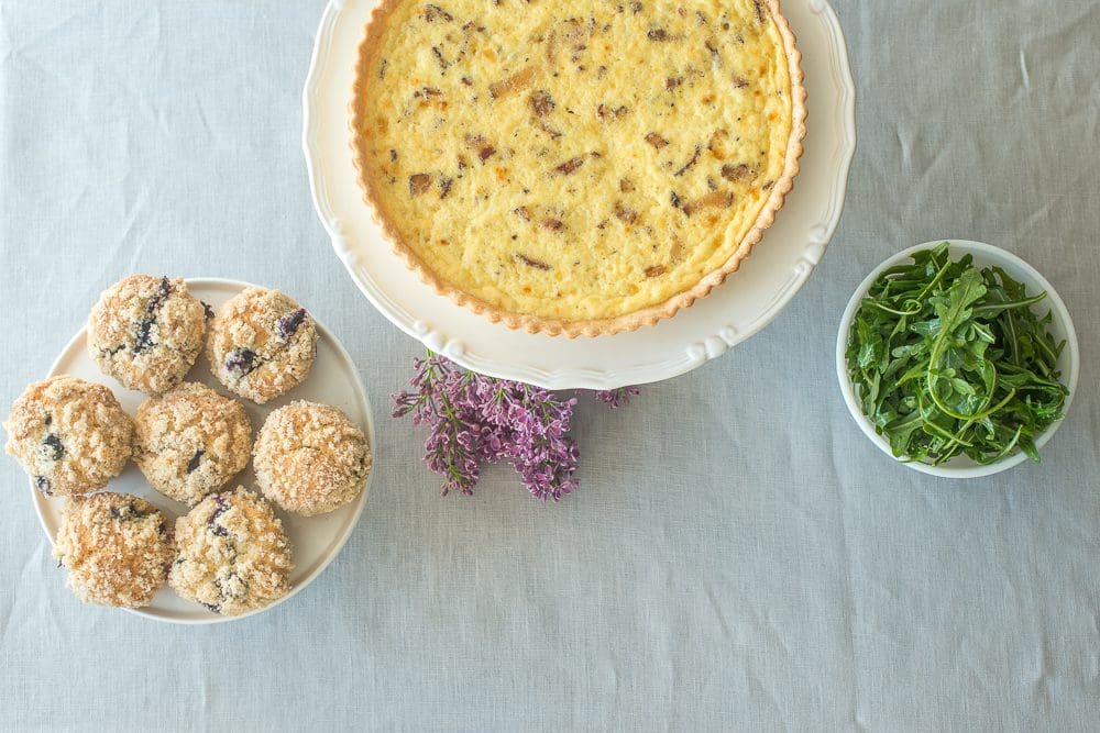 Quiche, muffins, and arugula on table