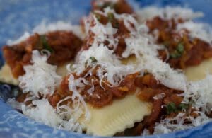 Pasta topped with grated cheese and sauce