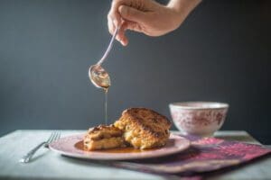 Pouring syrup over French toast breakfast