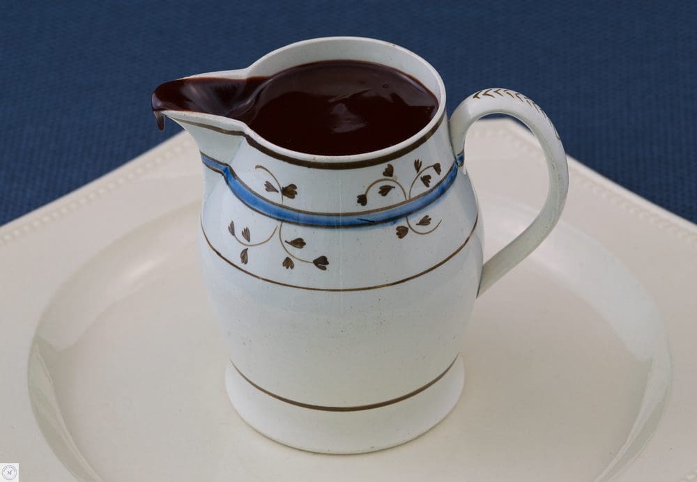 Handpainted jug overflowing glossy chocolate