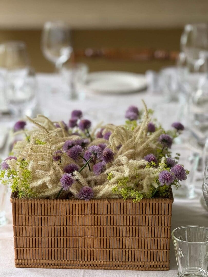 Purple and white flowers in wicker basket.