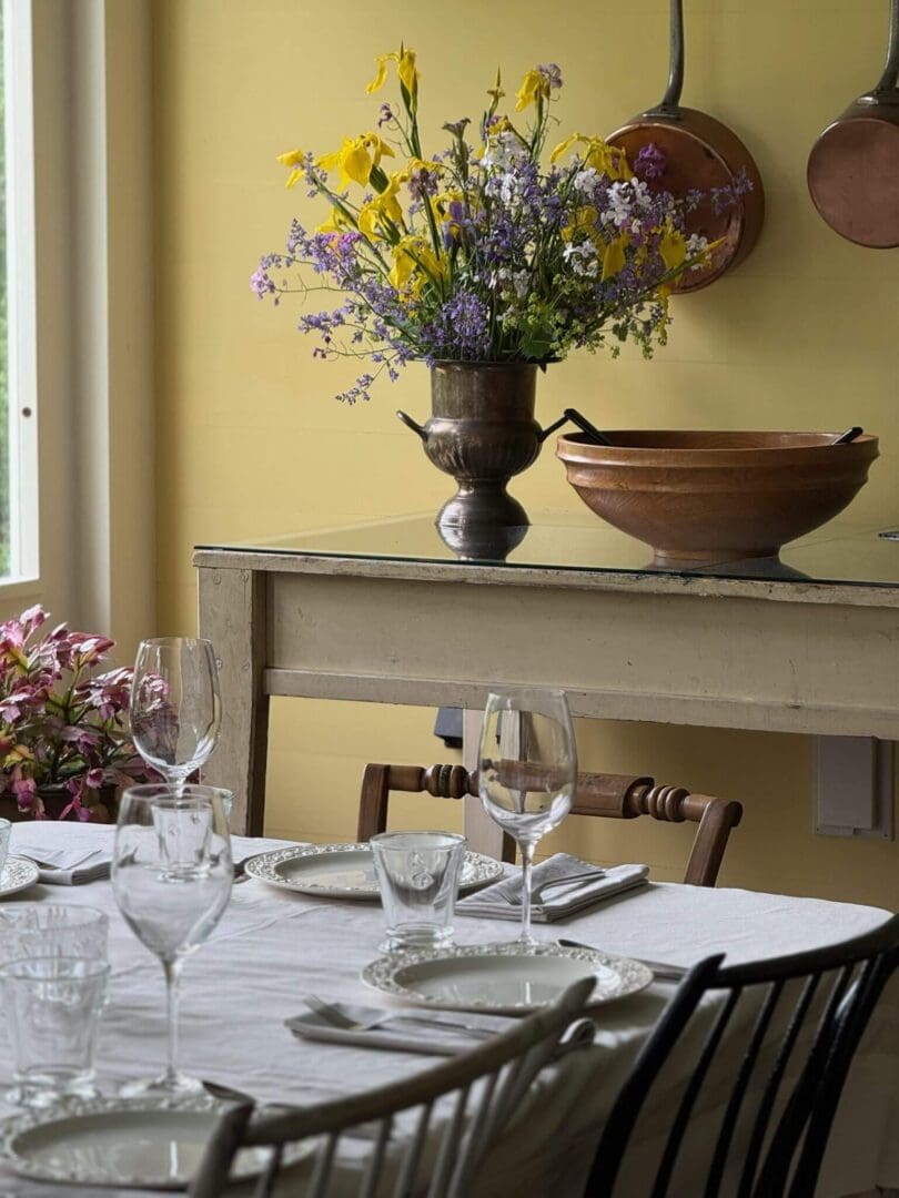 Dining table with flowers and copper bowls.