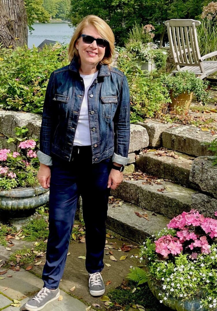 Woman in garden wearing denim jacket.