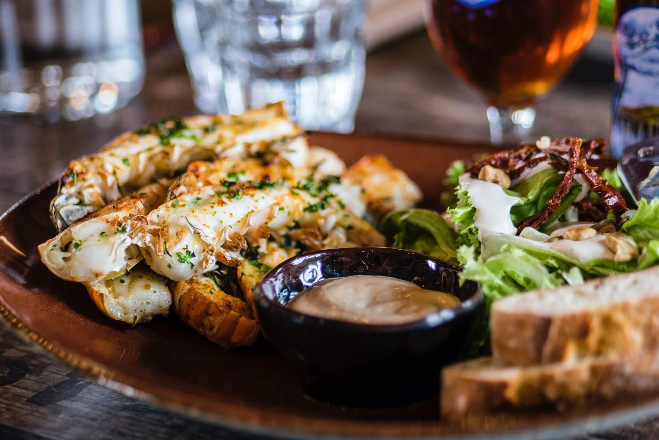 Seafood dish with salad and bread.