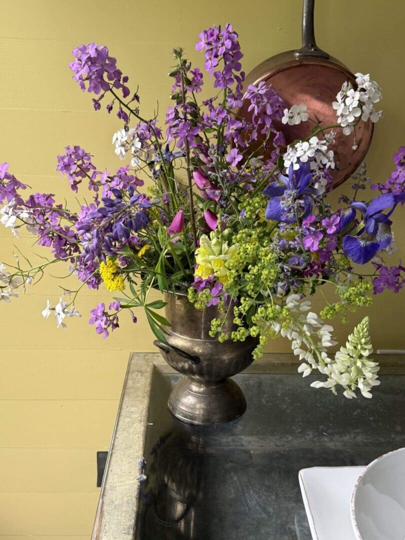 Colorful wildflower bouquet in a metal vase.