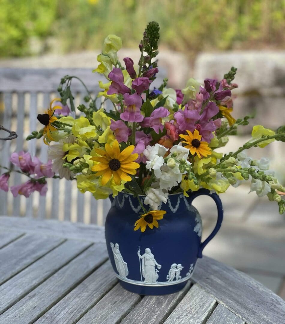 Colorful flowers in a blue decorative vase.